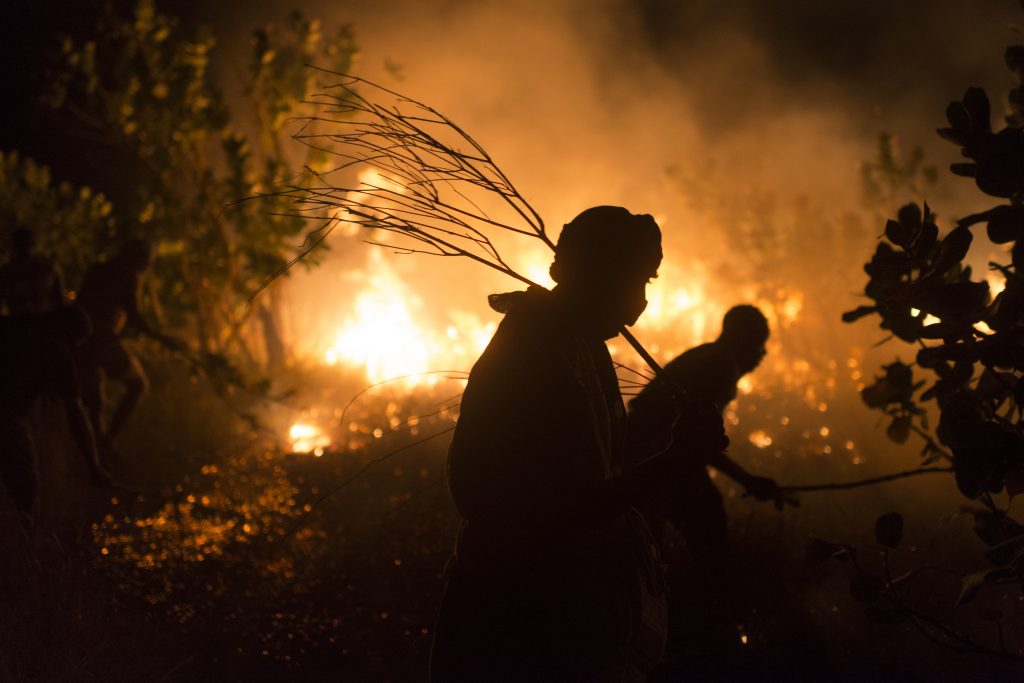 Los voluntarios se turnan para enfrentarse al agotador trabajo de apagar los incendios que se producen casi cada 48 horas durante la temporada de sequía. © ACNUR/Colin Delfosse