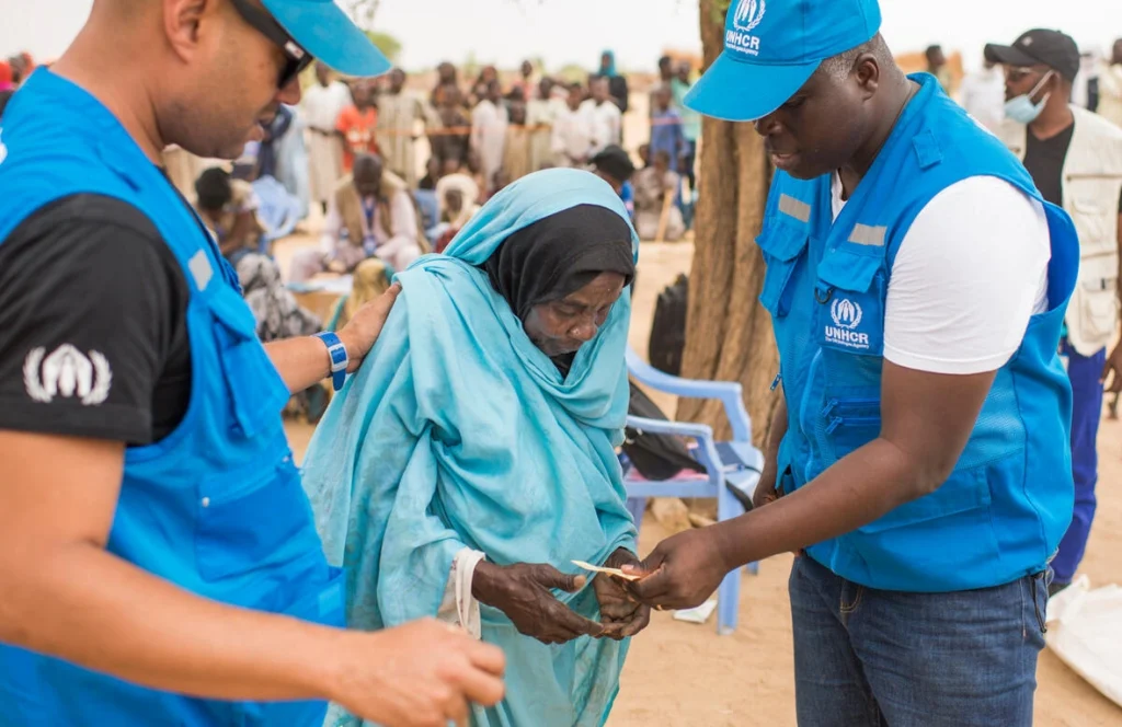La refugiada sudanesa Khadija Mahamat, de 72 años, es asistida por personal de ACNUR en el asentamiento de Madjigilta, en la región chadiana de Ouaddaï, en la frontera con Sudán. © ACNUR/Colin Delfosse