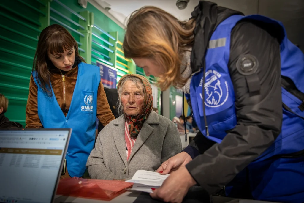 Lyzatska Mariia, de 72 años, evacuada de Kostiantynivka, recibe ayuda de la trabajadora social de Proliska Oksana Taranenko (a la derecha) en el centro de tránsito de Pavlohrad, al este de Ucrania.