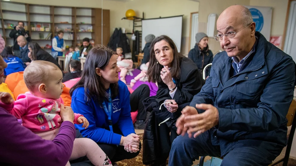 El Alto Comisionado de la ONU para los Refugiados, Barham Salih (a la derecha), habla con Nina (a la izquierda) en un centro de tránsito en Zaporizhzhia, al sureste de Ucrania, después de que ella fuera evacuada de su casa dañada por las bombas junto con su hija y sus tres nietos. © ACNUR/Nikola Ivanovski