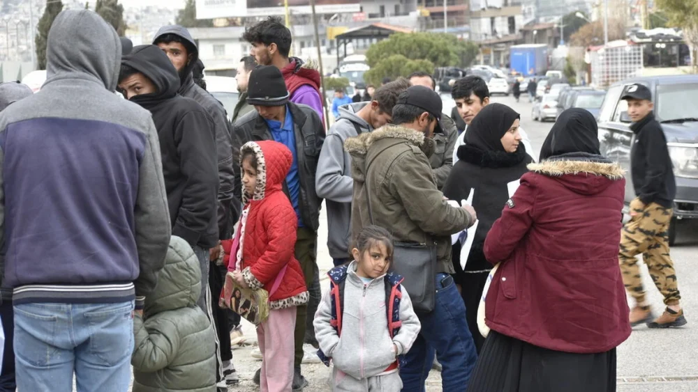 Un grupo de personas espera en el paso fronterizo de Masnaa, en el Líbano, para cruzar hacia Siria. © ACNUR